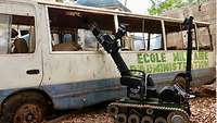 Ein Roboter hat seinen Greifarm durch eine defekte Scheibe in einen alten Bus gesteckt