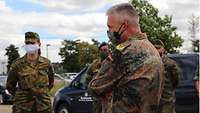 Generalarzt Dr. Most unterhält sich mit den Soldatinnen und Soldaten. Sie stehen mit Abstand zueinander in einem Halbkreis.