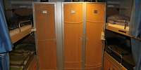 Eine Unterkunft der Mannschaften. In der Mitte ein Schrank mit drei Türen und links und rechts jeweils Doppelstockbetten.