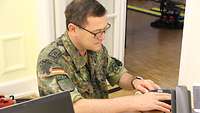Ein Soldat steckt ein Netzwerkkabel in einen Computer.