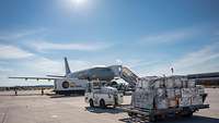 Im Vordergrund ein Frachttransporter mit dem Flugzeug A310 im Hintergrund