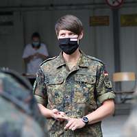 Eine Ärztin steht vor der Front der Truppe und hält eine Ansprache. 