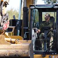 Ein Soldat sitzt in einem Bagger.