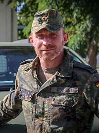 Ein Soldat vor einem Fahrzeug
