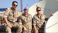 Drei Soldaten im Portrait, im Hintergrund eine Antenne 