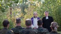 Ein katholischer und evangelischer Miilitärpfarrer halten einen Feldgottesdienst vor einer Gruppe von Soldaten