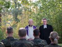 Ökumenischer Feldgottesdienst Ein katholischer und evangelischer Miilitärpfarrer halten einen Feldgottesdienst vor einer Gruppe von Soldaten