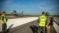 Der Eurofighter steht auf der Landebahn unter den Augen der estnischen Feuerwehr.