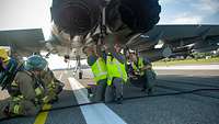 Die Crash-Crew drückt den Fanghaken am Eurofighter wieder in seine Ausgangsposition.