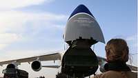 Über die Schulter einer Soldatin ist im Hintergrund die Antonov An-124 zu sehen. Die Nase ist aufgerichtet