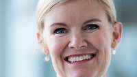 Prof. Dr. Rafaela Kraus ist eine blonde Frau, die bei diesem Portraitfoto in die Kamera lächelt