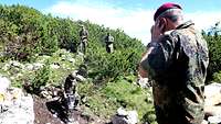 Ein Soldat zerkleinert mit einem Presslufthammer das Berggestein.