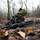 Ein Bundeswehrsoldat gleitet mit dem Gewehr G36 über den Waldboden