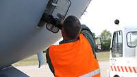 Ein Mann schließt den A400M an einen Stromgenerator an.