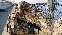 Ein Soldat mit der Maschinenpistole MP 7, im Hintergrund das Meer 
