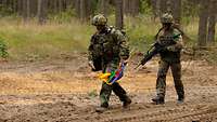 Zwei Soldaten mit bunten Flaggen im Wald 