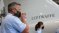 Ein Soldat zieht seine Maske an, bevor er das Flugzeug betritt.
