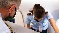 Eine Soldatin bereitet einen Sitz im Flugzeug vor.