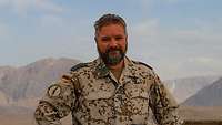 Ein Soldat im Portrait, im Hintergrund das Marmal-Gebirge
