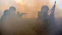 Soldaten begeben sich in einer Nebelwand in Deckung