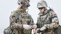 Zwei Soldaten stehen nebeneinander und besprechen sich untereinander