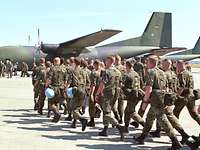 Soldaten auf dem Flugplatz laufen auf eine Transall-Maschine zu 