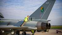 Ein deutscher Techniker steht auf dem linken Flügel des Eurofighter und inspiziert den Jet nach der Landung.