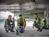 Gemeinsame Besprechung unter dem britischen Eurofighter Ein britischer und zwei deutsche Techniker in einer Besprechung unter einem Eurofighter auf dem Flugplatz in Ämari.