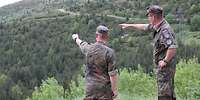 Zwei Soldaten blicken in das Gelände 