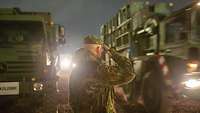Abmarsch der Alpha-Staffel aus Rena nach Sølenstua Soldat salutiert den wegfahrenden LKWs