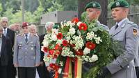 Zwei Soldaten halten einen Kranz zum 70. Todestag von Generalmajor Henning von Tresckow