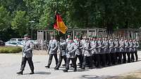 Soldaten maschieren mit der Truppenfahne