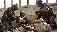 Two soldiers attend to an injured comrade.