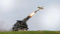 : A Small Aircraft for Target Acquisition (KZO) is launched from a truck-mounted container, leaving a fire trail and smoke.