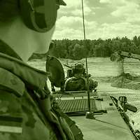 A platoon leader observing the Dachs armoured engineer vehicle at work.