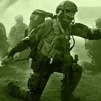 Five soldiers crouch in an open space. One soldier throws a smoke pot while four others secure the surroundings.