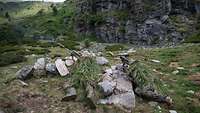 Two fully camouflaged soldiers lie in mountainous terrain and observe the scene in front of them.