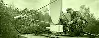 The signal corps establishes and maintains communications. A soldier setting up a satellite antenna on a rooftop.
