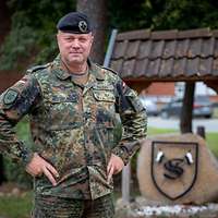 Ein Soldat mit schwarzem Barett stemmt die Hände in die Seiten und schaut in die Kamera.