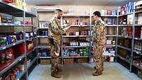 Zwei Soldaten stehen sich gegenüber in einem Shop Produkte für den täglichen Bedarf erhältlich sind