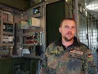 Schaltschrank Ein Soldat steht vor einem Schaltschrank