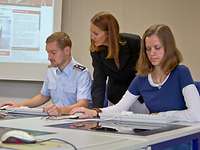 Eine Beamtin und ein Soldat mit ihrer Lehrerin im Sprachkurs.