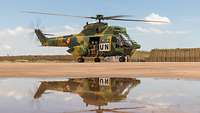 Deutsche und rumänische Soldaten winken aus einem Hubschrauber