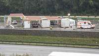 Blick auf die Teststation: Zwischen zwei Container ist Platz für ein Auto. Rechts im Bild steht ein Rettungsfahrzeug.