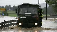 Ein Bundeswehr-LKW watet durch Hochwasser.