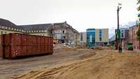 Blick auf Baustelle im Nahbereich mit Container, Kran und unbebautem Bodenbereich
