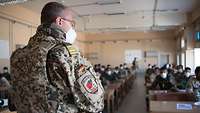 Ein deutscher Soldat in Uniform steht in einem Unterrichtsraum vor afghanischen Soldatinnen und Soldaten