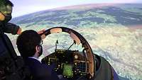 Zwei Männer befinden sich in einem Flugzeugsimulator.