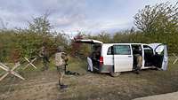 Soldaten durchsuchen einfahrende Fahrzeuge am Checkpoint.