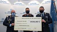 Oberstabsfeldwebel Weimer, Generalmajor Ohl und Oberstabsfeldwebel Haas halten den großen Scheck in die Kamera